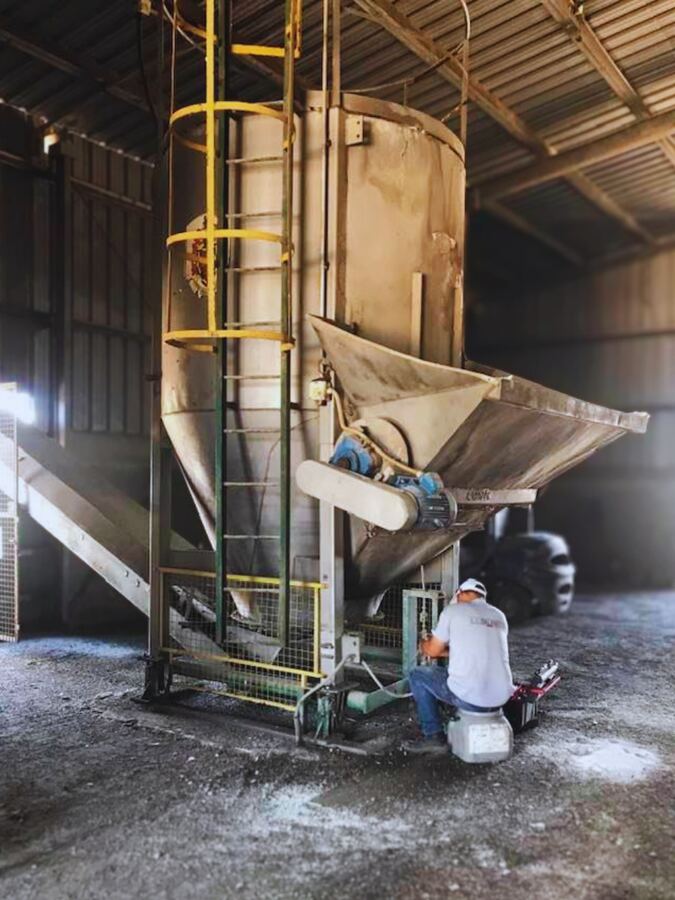 Técnico reparando sistema de pesaje en molino